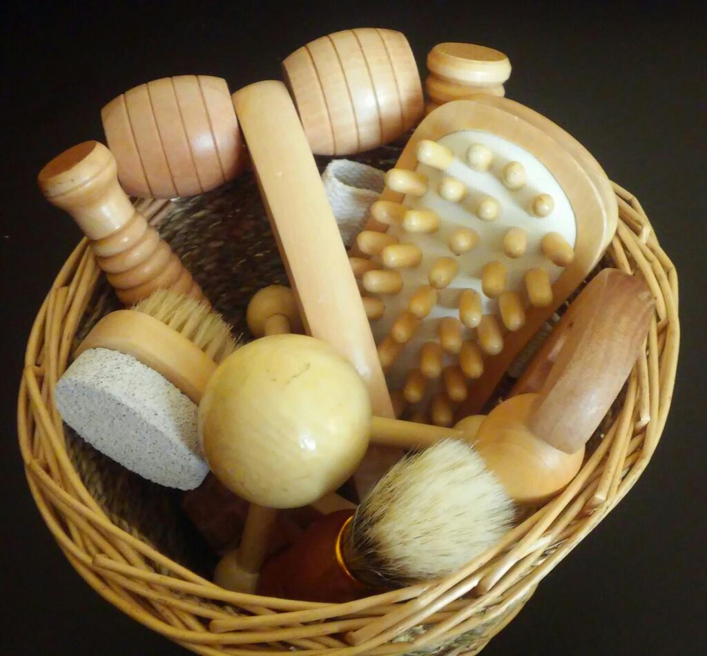 Top view of various wooden massage tools neatly arranged in a woven basket.