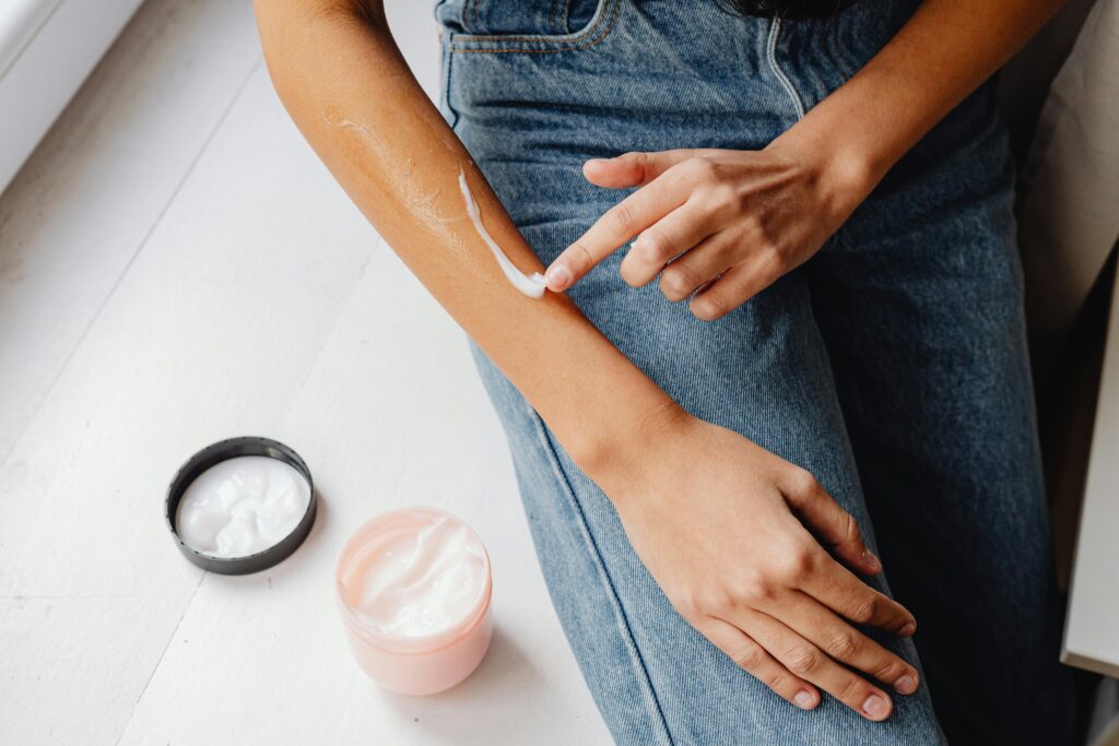 Retinol for Beginners: Gentle Serums for Glowing Skin Close-up of a person applying hand cream on their arm, emphasizing skincare and hydration.