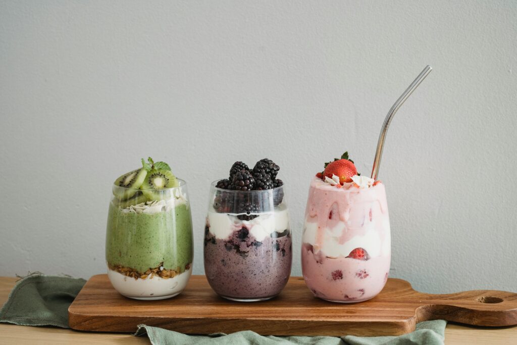 Boost Your Mornings with Ka’chava Nutrition Shakes Colorful homemade fruit smoothies with kiwi, blackberry, and strawberry on a wooden board.